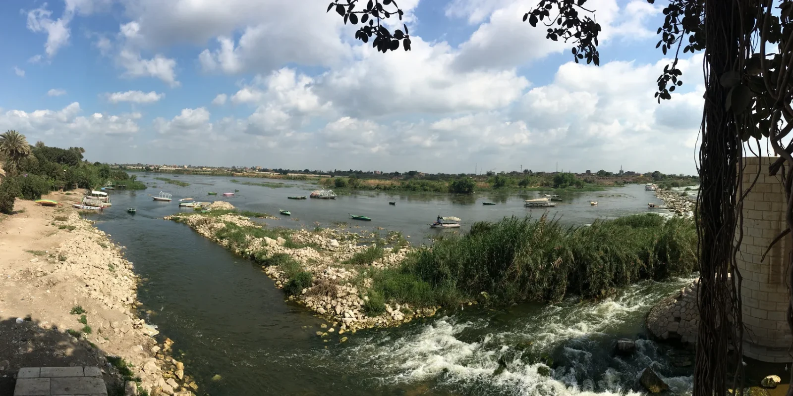 Boats, vegetation and water beside the Rosetta Barrage at El Qanater El Khayreya